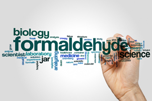 a hand with a pen writing a word cloud featuring formaldehyde as the largest term